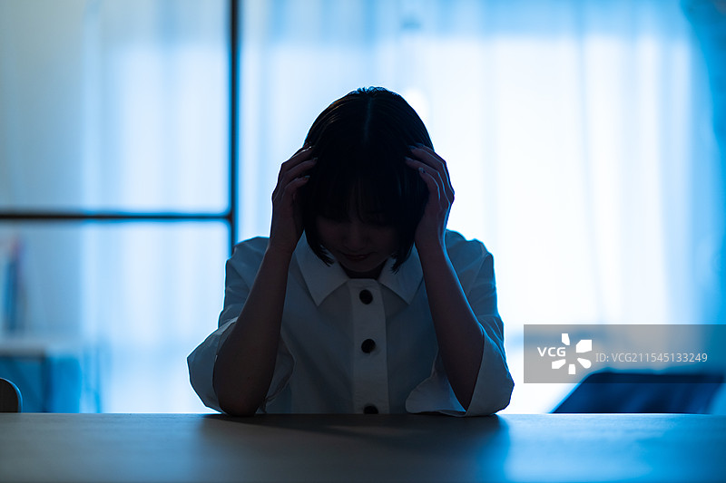 年轻女性在房间里显得沮丧图片素材