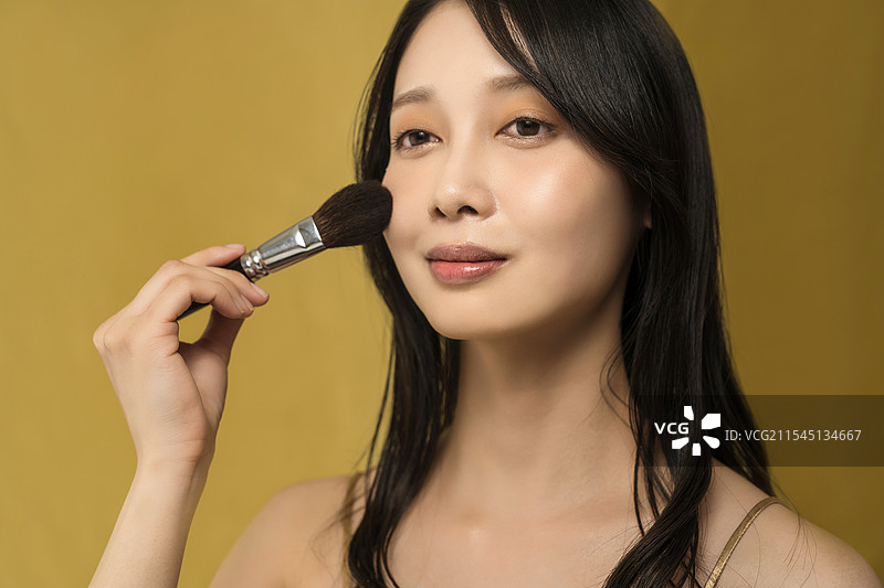 女性正在化光泽妆图片素材