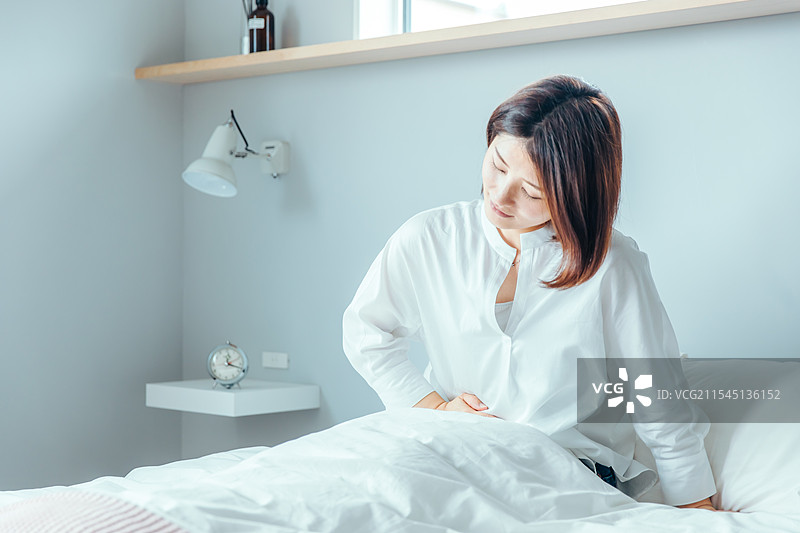 身体不适的女性捂着肚子图片素材