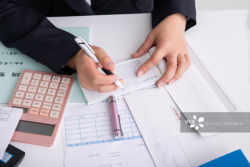 穿着西装的女性在进行会计工作图片素材