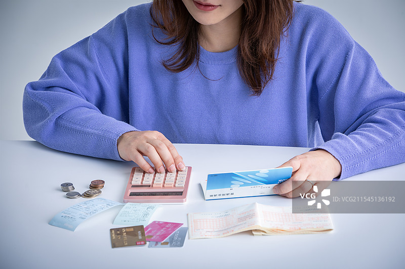 女性在计算器上进行计算图片素材