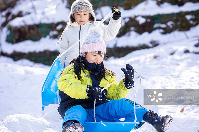 两个孩子在雪橇上玩耍图片素材