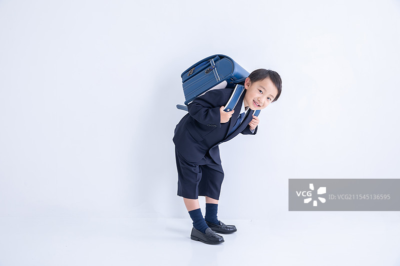 穿着西装的男孩背着书包图片素材
