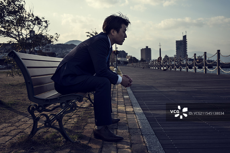 商人坐在公园长椅上图片素材