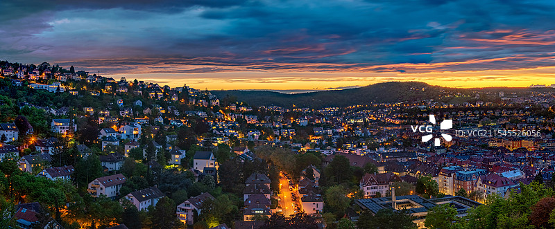 晚霞映照下的城市夜景，橙色与蓝色交织，建筑物和街道灯光闪烁，宁静而美丽。图片素材
