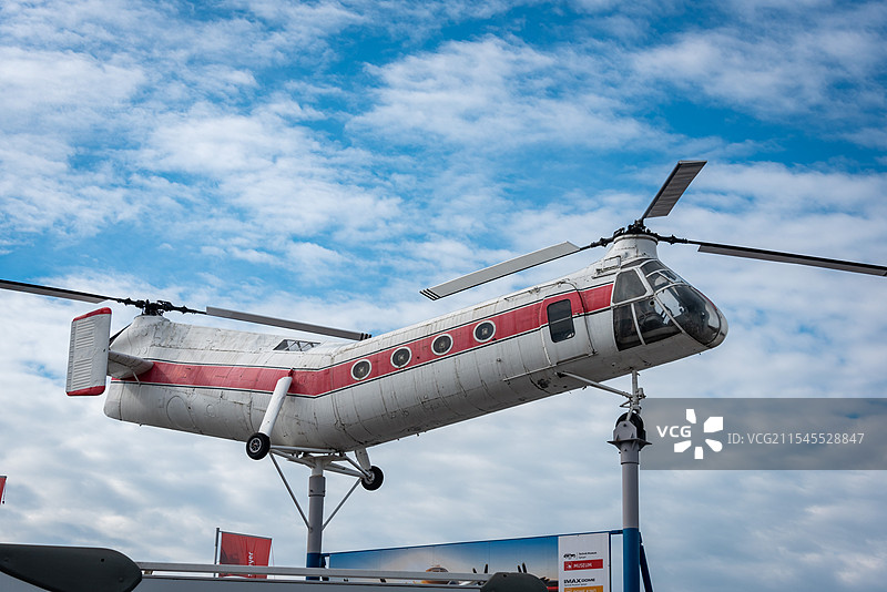 一架红白相间的支奴干直升机悬挂在支架上展览，透明的驾驶舱展示了现代科技的魅力图片素材