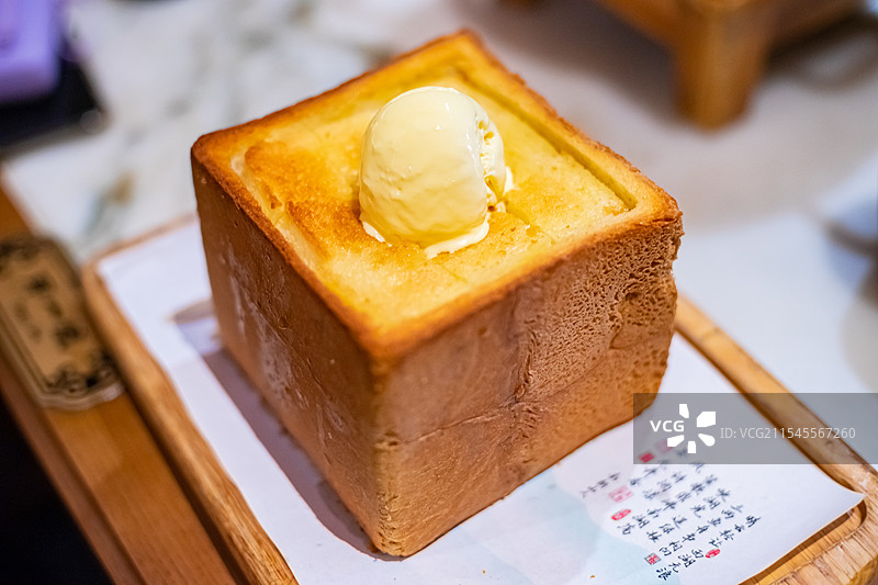 中国餐饮行业饮食产业拍摄主题，高视角俯拍盘子里金黄色的面包诱惑主食，室内无人图像摄影图片素材