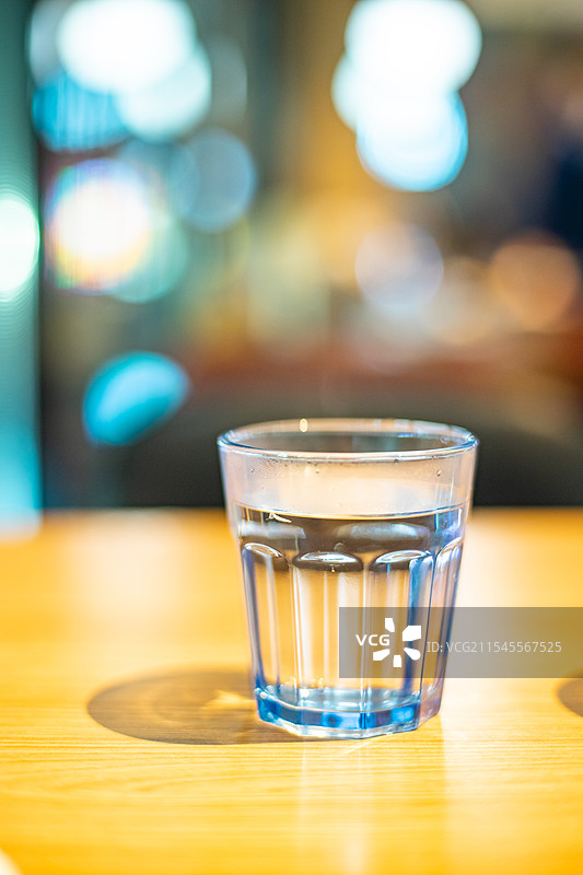 中国城市健康生活拍摄主题，住宅内部环境，茶几上的玻璃杯和柠檬水，背景是城市夜景，室内无人图像摄影图片素材