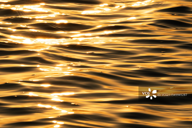 日落时金黄色波光粼粼的海面图片素材