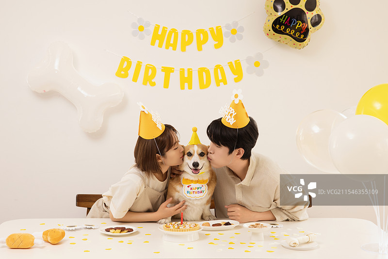 一对年轻情侣正在为他们的狗狗生日派对做准备图片素材