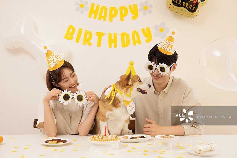 一对年轻情侣正在为他们的狗狗生日派对做准备图片素材