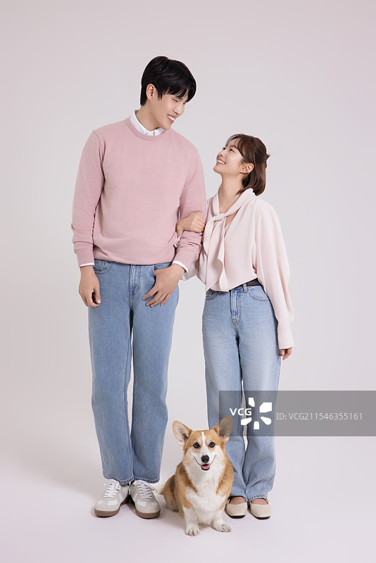 年轻夫妇与可爱的威尔士柯基犬的家庭合影图片素材