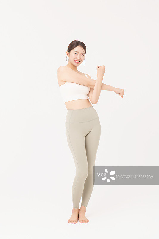 年轻女性穿着运动服拉伸的肖像图片素材