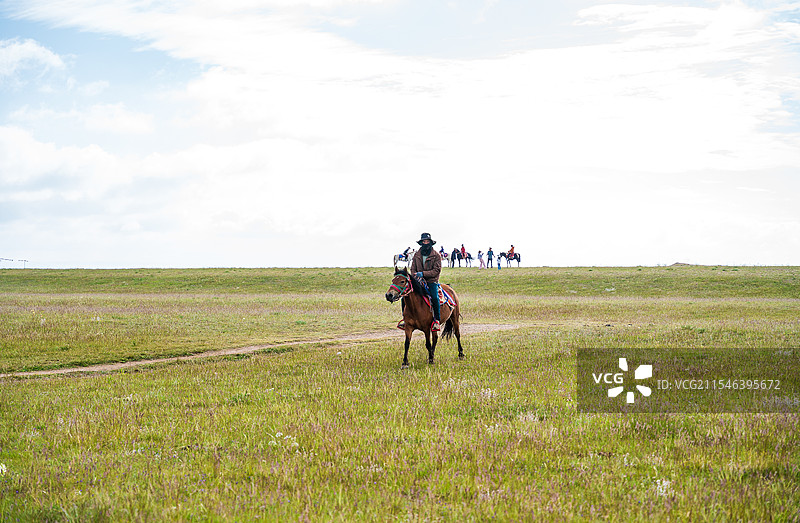 广阔草原上的牧马人图片素材