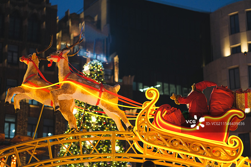 夜晚圣诞集市上的麋鹿拉圣诞老人雪橇的装置艺术雕塑图片素材