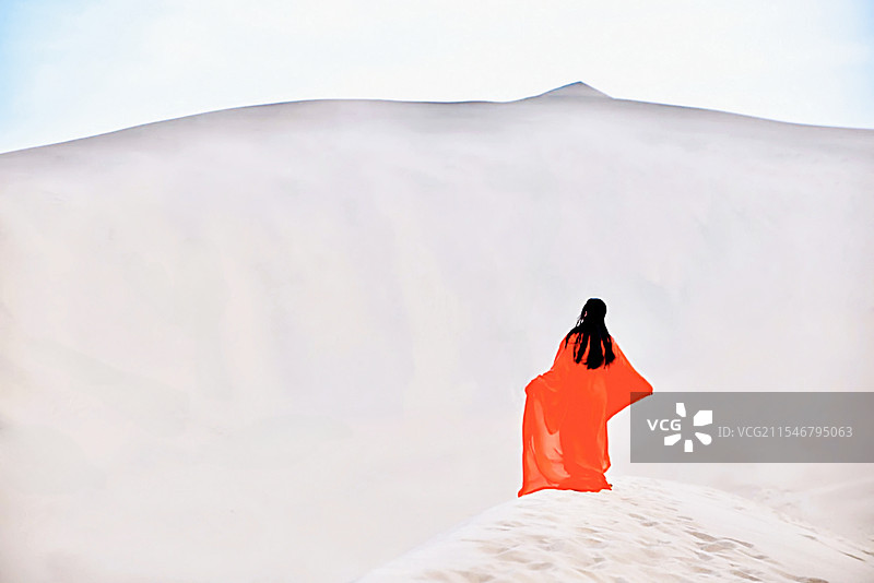 中国内蒙古阿拉善沙漠中大漠黄沙背景中的红衣女性女子女孩背影图片素材