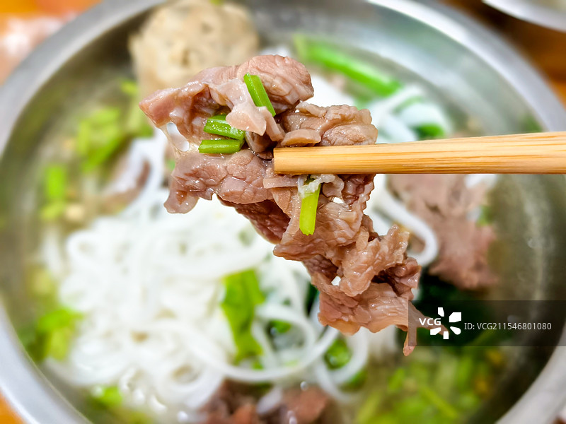 广东省省盆盛放的潮汕牛肉粿条，用筷子夹起一块牛肉图片素材