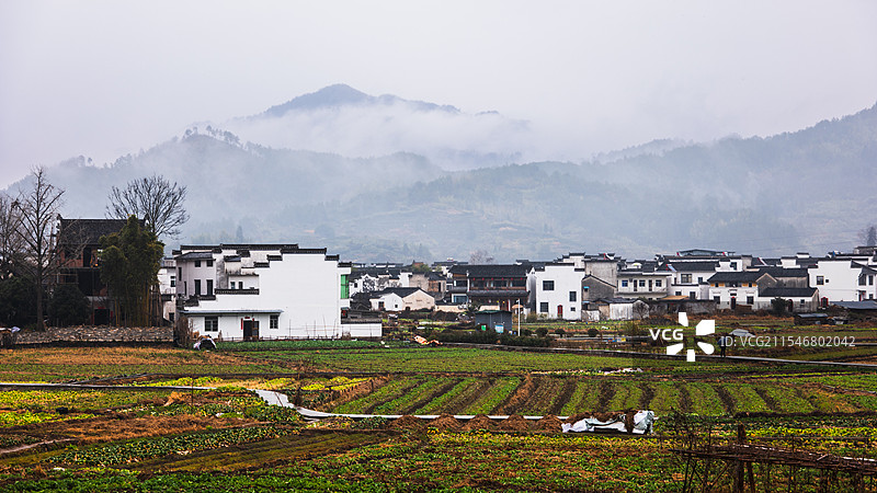 山脚下雨雾中的村庄摄于安徽呈坎八卦古村图片素材