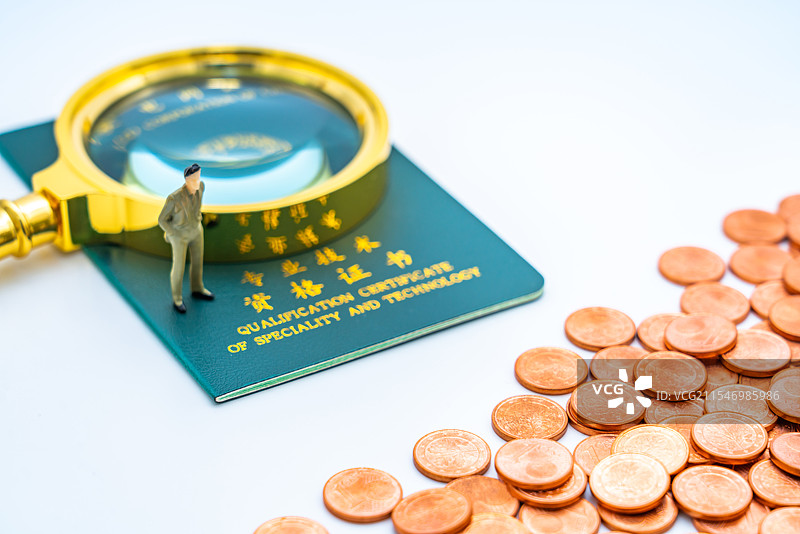 白色背景下的专业技术资格证书、放大镜和玩具小人图片素材