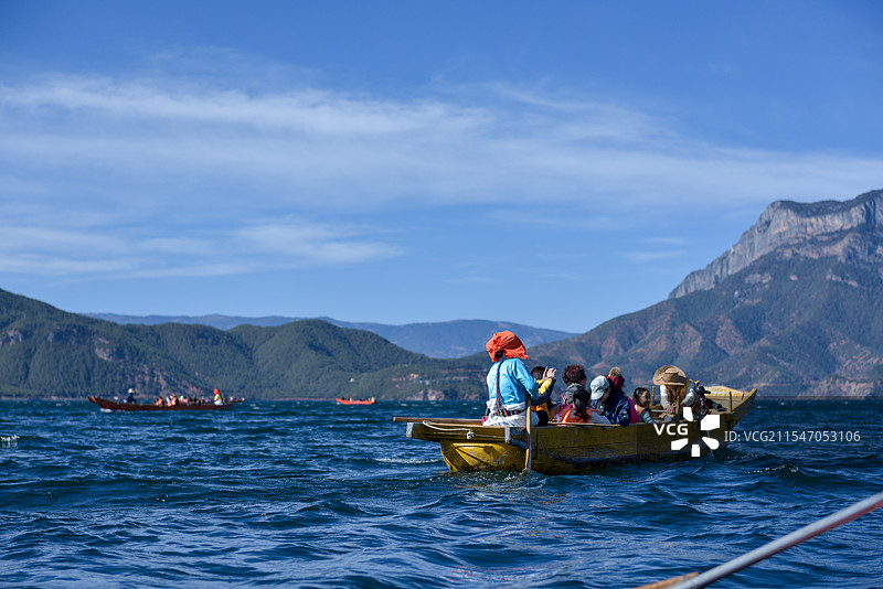 泸沽湖湖面上载着游客的多彩船只图片素材