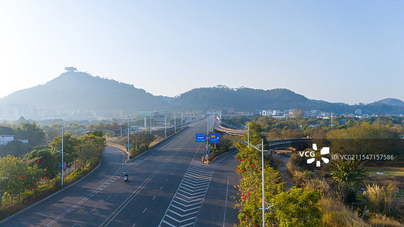 航拍冬季清晨阳光下广东梅州神光山旅游景区前空旷的城市道路图片素材