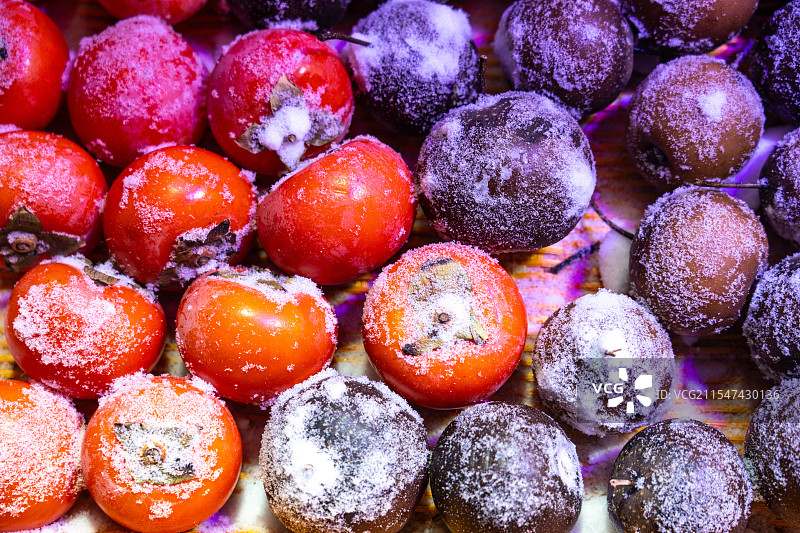 冬天中国雪乡售卖的冻梨、冻柿子等冻水果图片素材