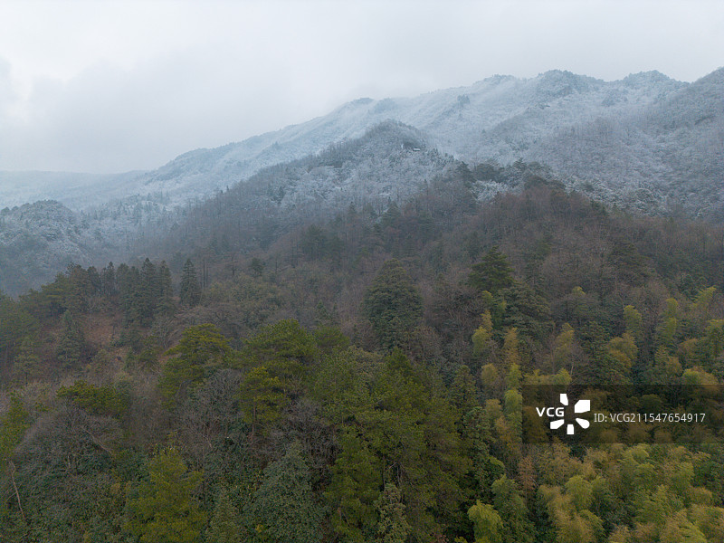 浙江杭州临安山上的雪线，山顶的积雪与山腰的绿色对比明显图片素材