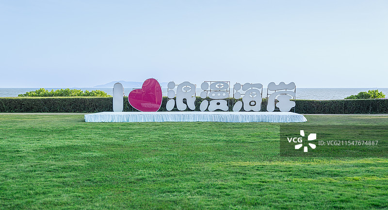 广东茂名浪漫海岸旅游度假区，绿色草地上的文字“我爱浪漫海岸”图片素材