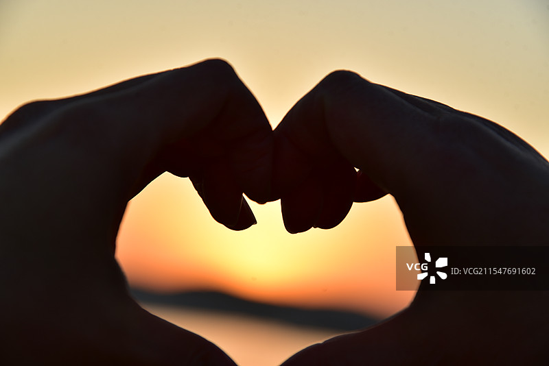 夕阳前的比心图片素材