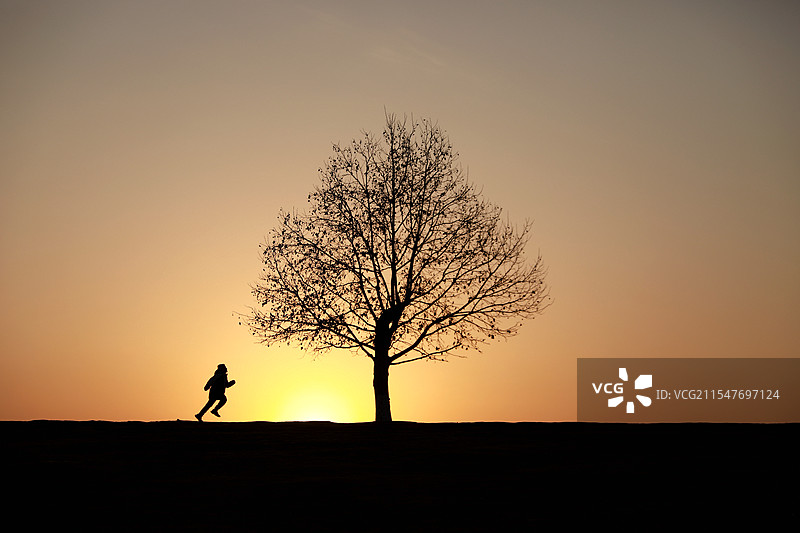南京钟山风景区夕阳下奔跑的少年图片素材