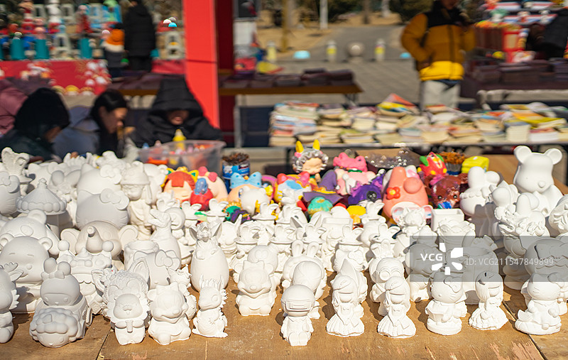 中国文化娱乐拍摄主题，桌子上的成一排休闲游戏石膏涂色娃娃玩具，户外白昼无人图像摄影图片素材