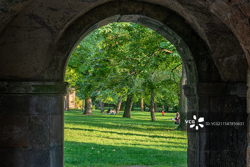 斯图加特孤独城堡，阳光透过树叶洒在绿草地上，石拱门图片素材