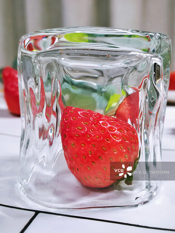 透明玻璃杯中的红色冰草莓图片素材
