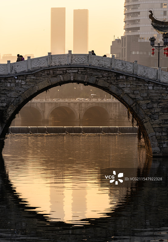 贵阳花果园双子塔黄昏倒影：浮玉桥桥洞与水中圆圈的完美构图图片素材