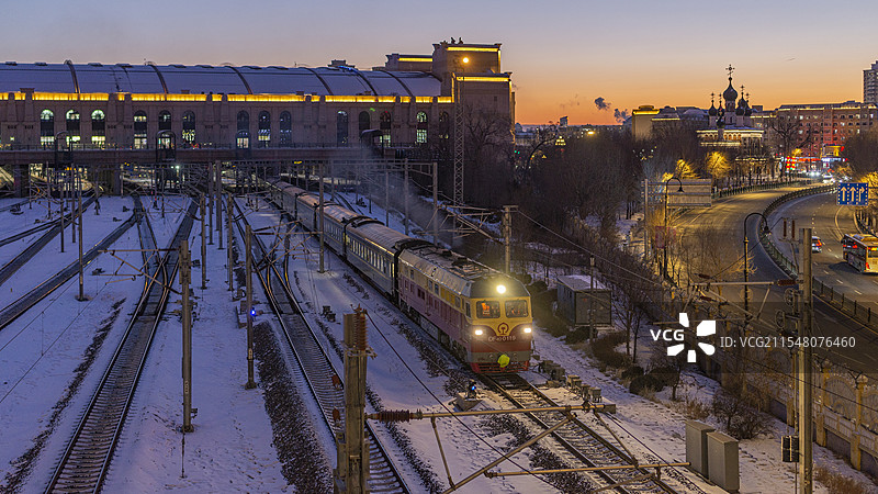 开往漠河的“雪国列车”K7039次暮色时分离开哈尔滨站图片素材