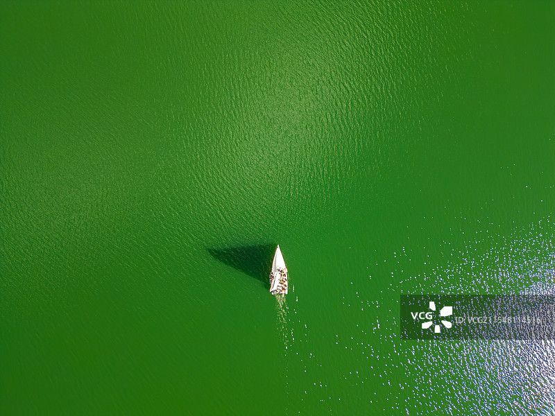 绿色湖面上孤船的航拍画面图片素材