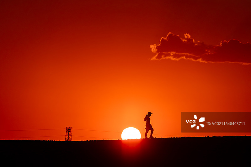 新疆哈密戈壁地平线日落-摄影师剪影图片素材