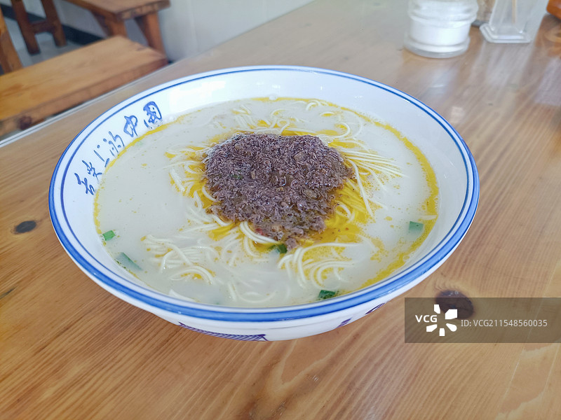 餐馆木质餐桌上俯拍虾籽酱浇头东台鱼汤面特写图片素材