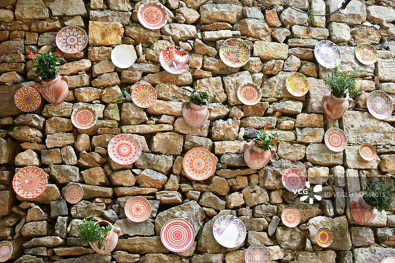 古村落墙上各种各样花纹的盘子图片素材