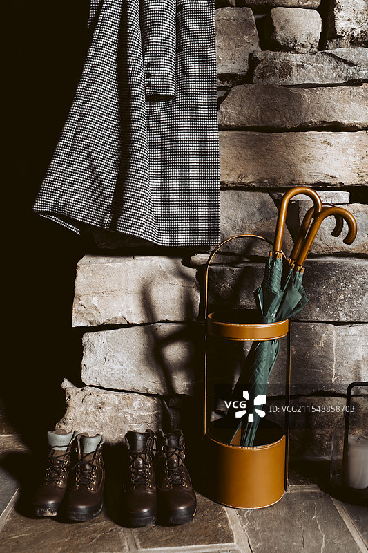 石墙上放着登山靴、外套和雨伞图片素材