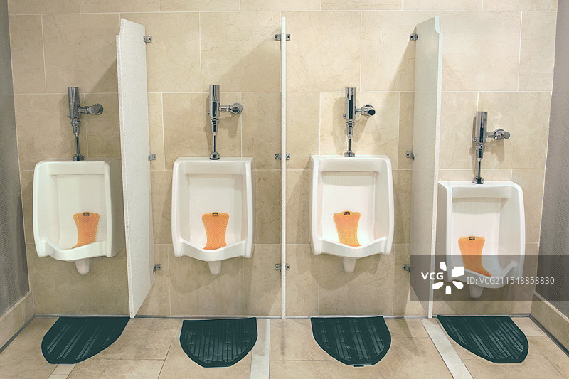 公共厕所里排成一排的四个小便池图片素材