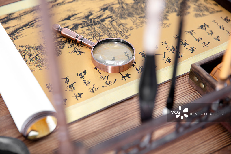 放大镜在中国传统水墨画上图片素材