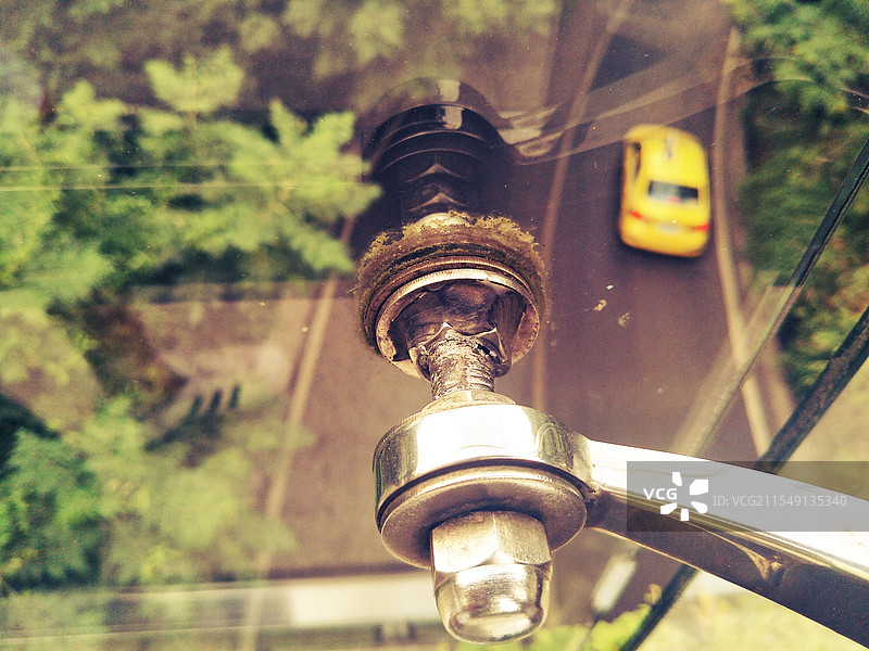 天桥上透过玻璃围栏俯视路上的黄色出租车图片素材