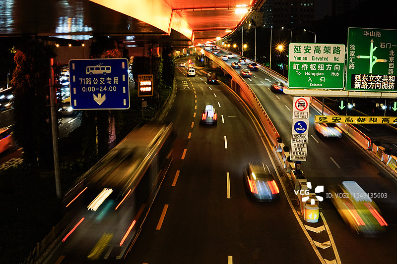 夜晚高架桥入口出路面上飞驰的汽车与灯光图片素材