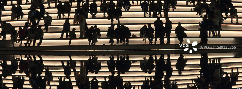 在广州塔广场水池旁休息的人群剪影与水面倒影图片素材