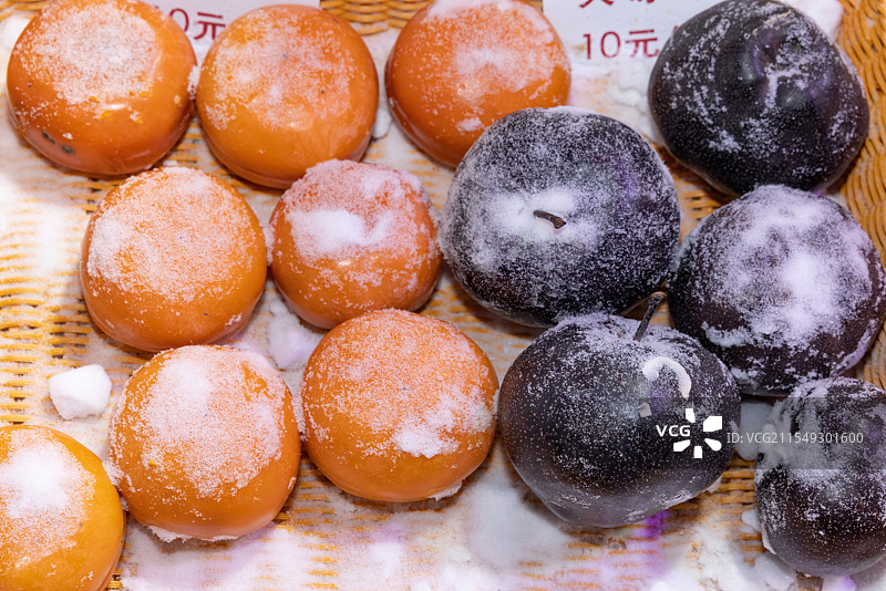 冬天中国雪乡水果摊位销售的冻梨、冻柿子等冰冻水果图片素材