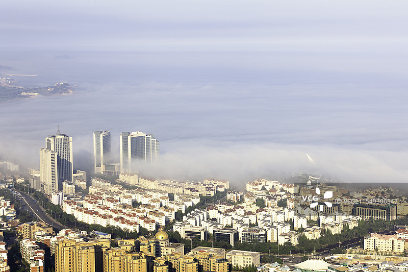 高视角海滨城市的平流雾图片素材