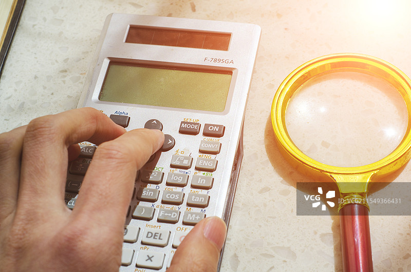 在书桌上按计算器图片素材