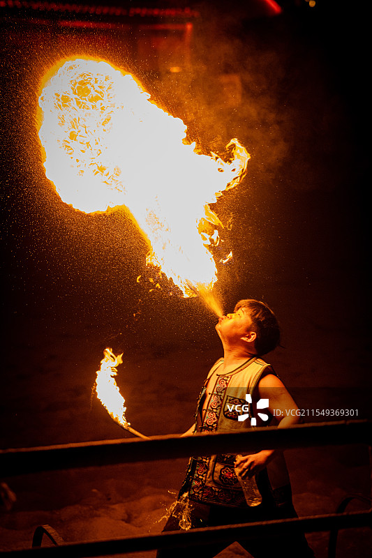 一位男人正在表演非遗节目中的喷火图片素材