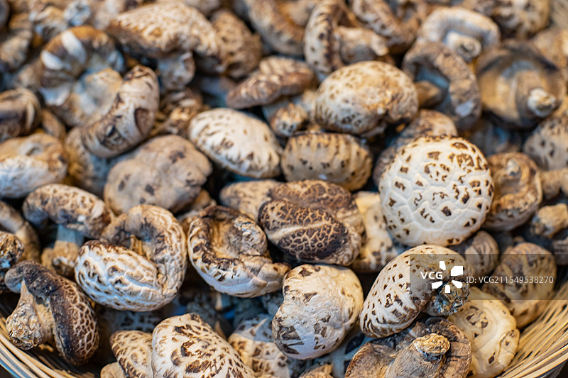 中国五谷杂粮拍摄主题，竹子编织的竹筐里拍摄一堆褐色的干燥食品香菇，室内无人图像摄影图片素材